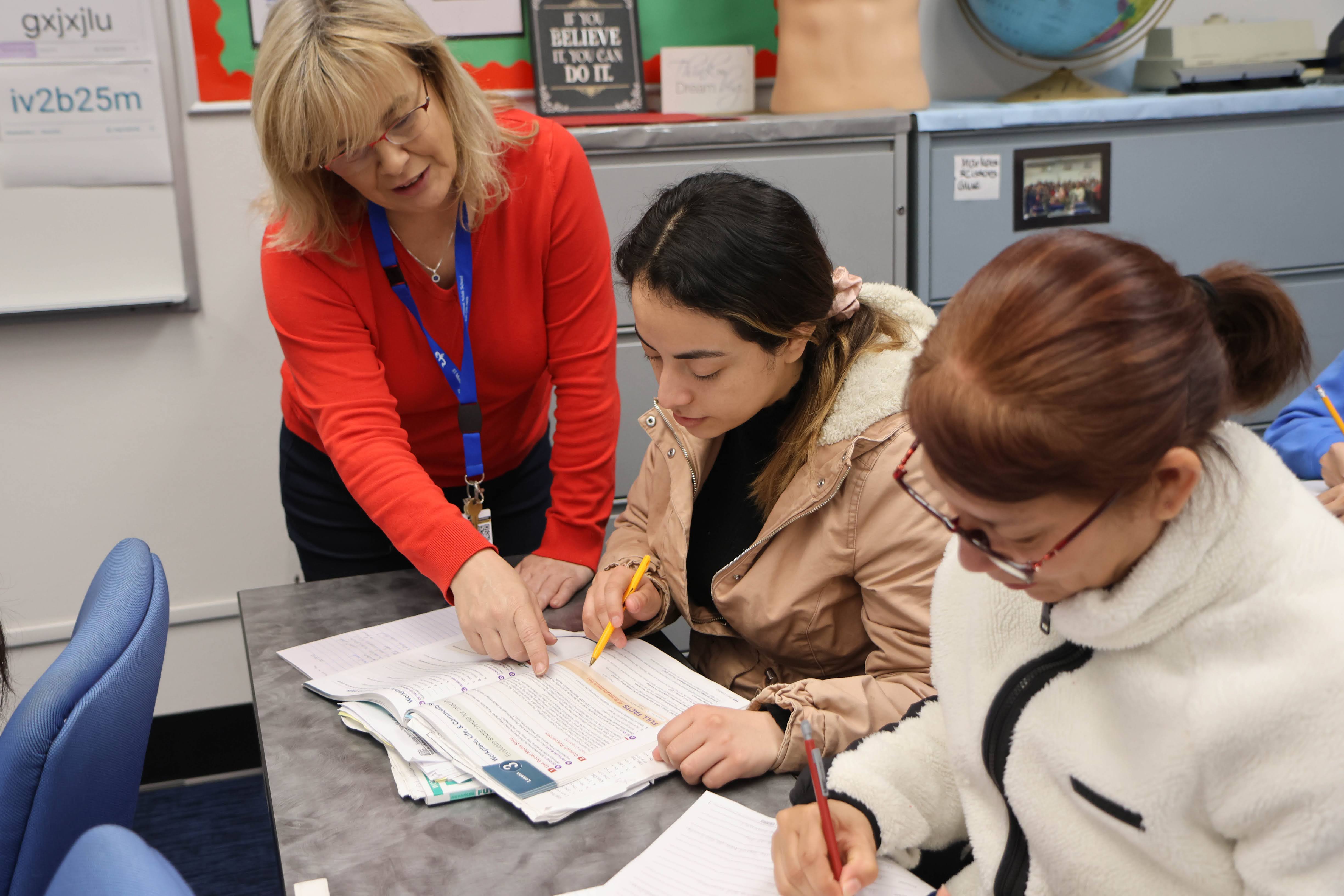 Teacher helping students at the desk